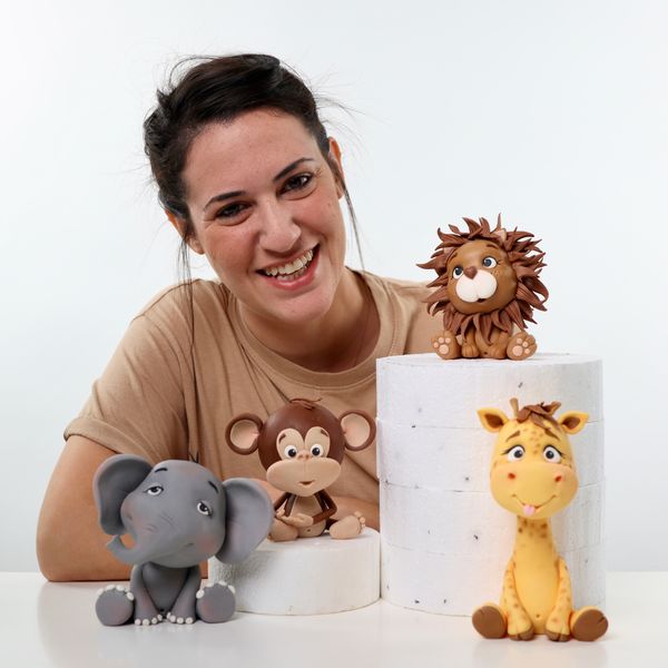 קארין עמנואל עם חיות הספארי אריה ג׳ירפה קוף פיל מפוסלים בבצק סוכר