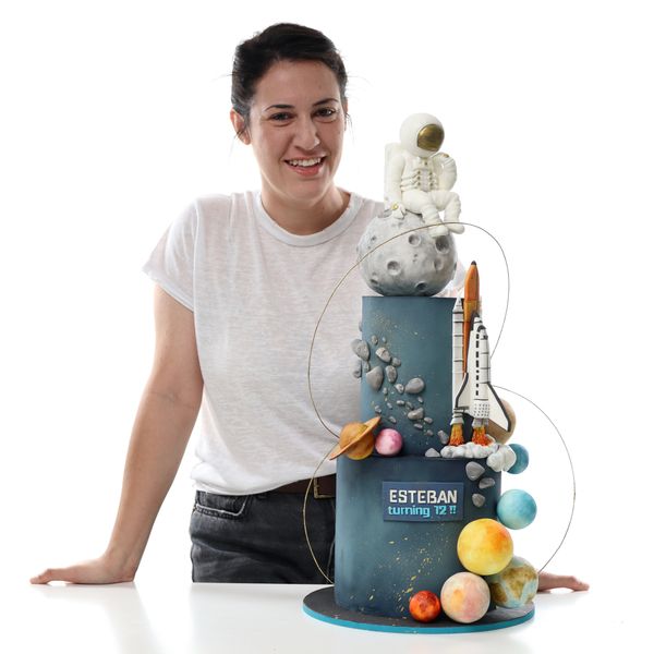 קארין עמנואל עם עוגת קומות של מסע בחלל מעוצבת בבצק סוכר
