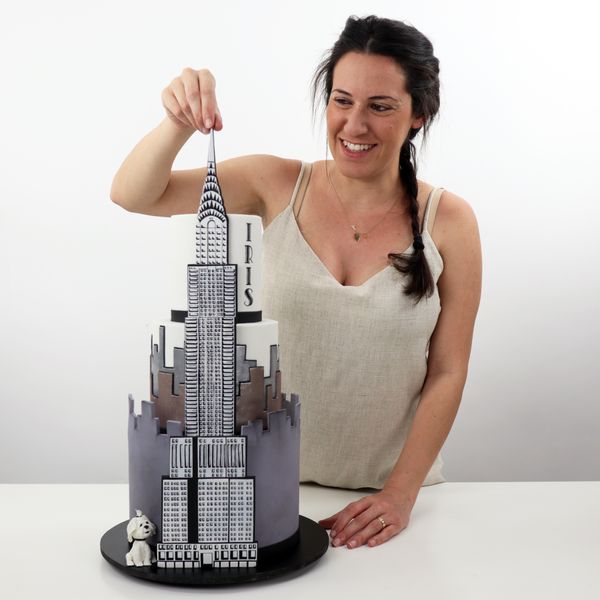 קארין עמנואל עם עוגת ניו יורק של בניין האמפייר סטייט מפוסלת בבצק סוכר בעבודת יד ליום הולדת לאישה